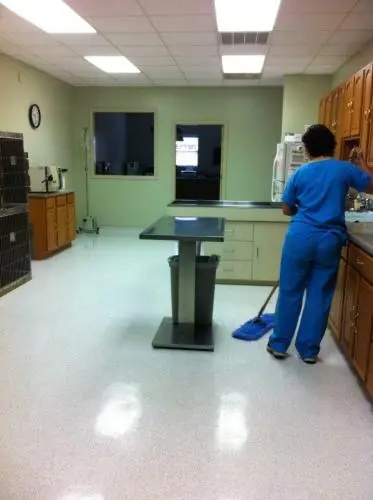 A very large well lit room at Houston Lake Animal Hospital. The room is clean and has a large metal table in the center of the room surrounded by countertops and testing equipment.