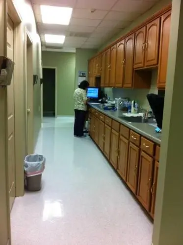 The back hallway at Houston Lake Animal Hospital. The hallway is clean and well lit with a few doors on either side of the hallway. In the middle of the hallway is a long countertop that had testing equipment and computers on top of it.